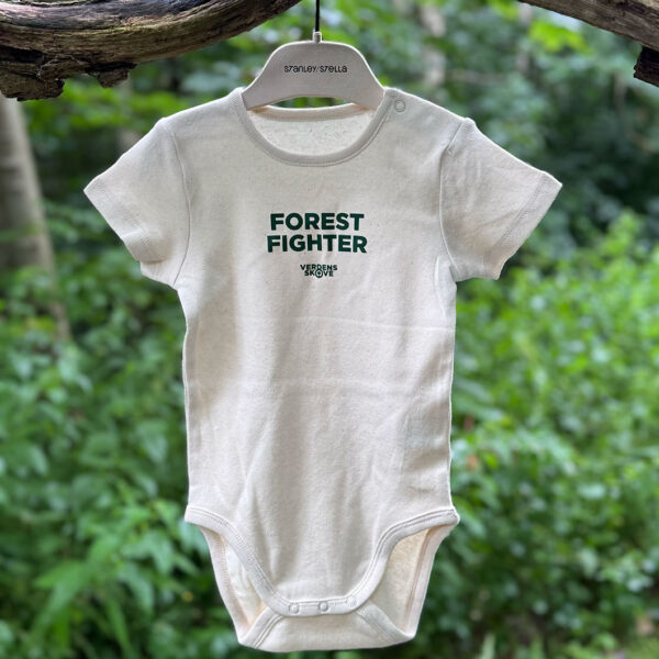 Baby body tøj Forest Fighter i naturfarvet stof med grønt tryk hænger på en bøjle i skoven