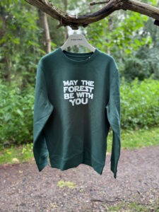 Crewneck sweatshirt i mørkegrøn med hvidt “May the Forest Be With You”-tryk på forsiden