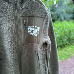 Nærbillede af fleecetrøje dame herre med brystlomme, lynlås og hvidt “May the Forest Be With You”-tryk